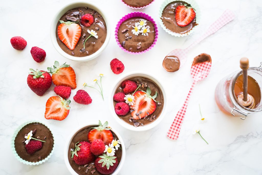 Mindful eating - little chocolate dessert puddings with strawberries and flowers on top.