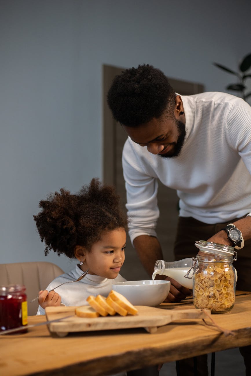 positive black father and daughter having breakfast